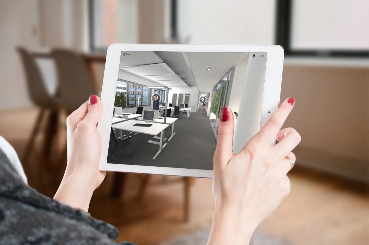 iPad zeigt virtuelle Bürobegehung im Siemens Campus – 3D-gerenderte Bürolandschaft mit Arbeitsplätzen und Avataren